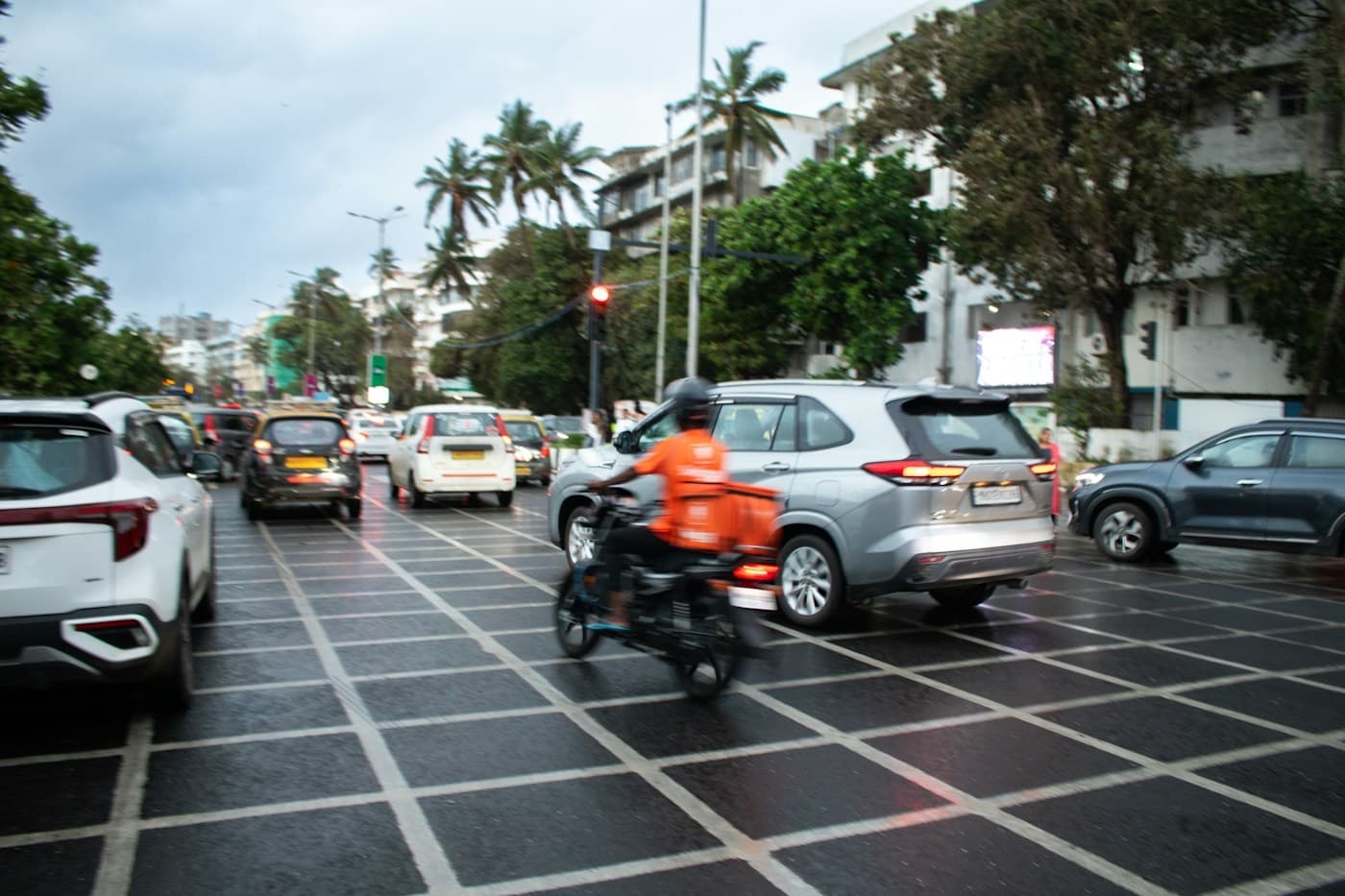 Motociclista parado entre os carros em um cruzamento movimentado