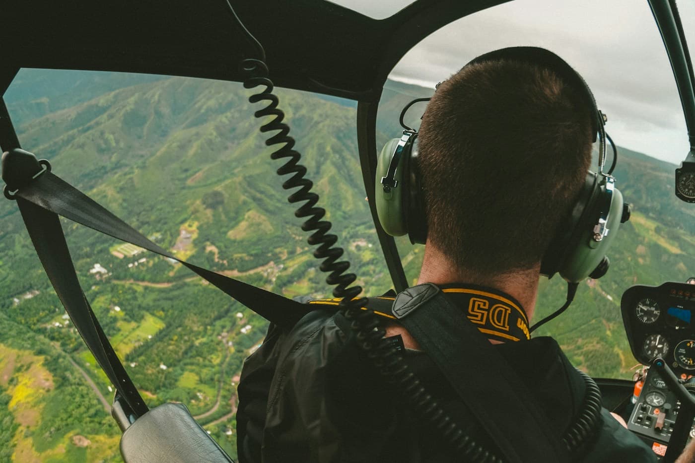 Piloto de helicóptero em voo, visto de dentro da cabine