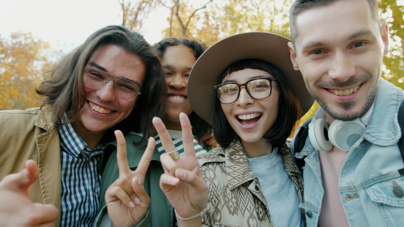Amigos sorrindo e fazendo pose para uma selfie no parque