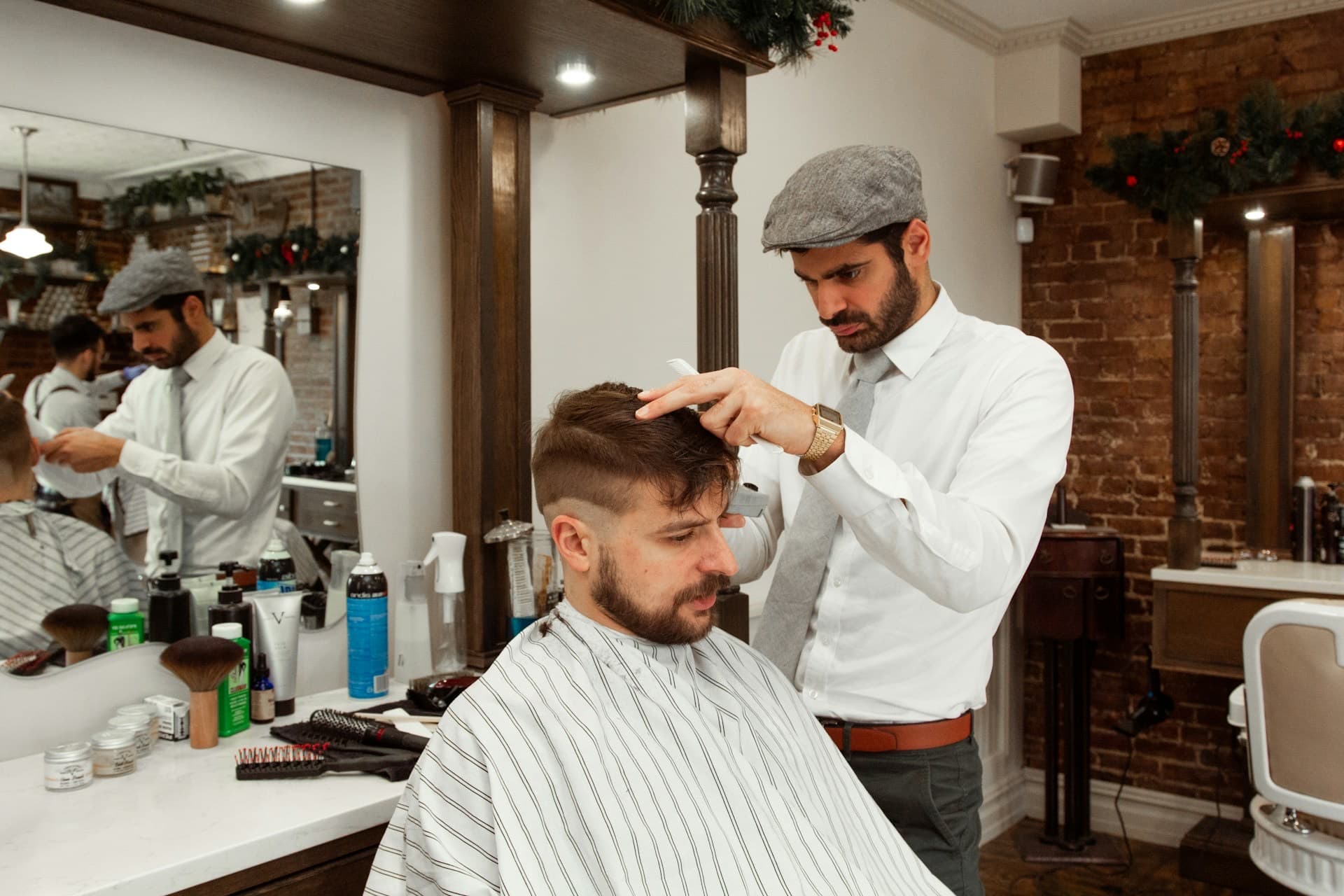 Barbeiro cortando o cabelo de um cliente em sua barbearia