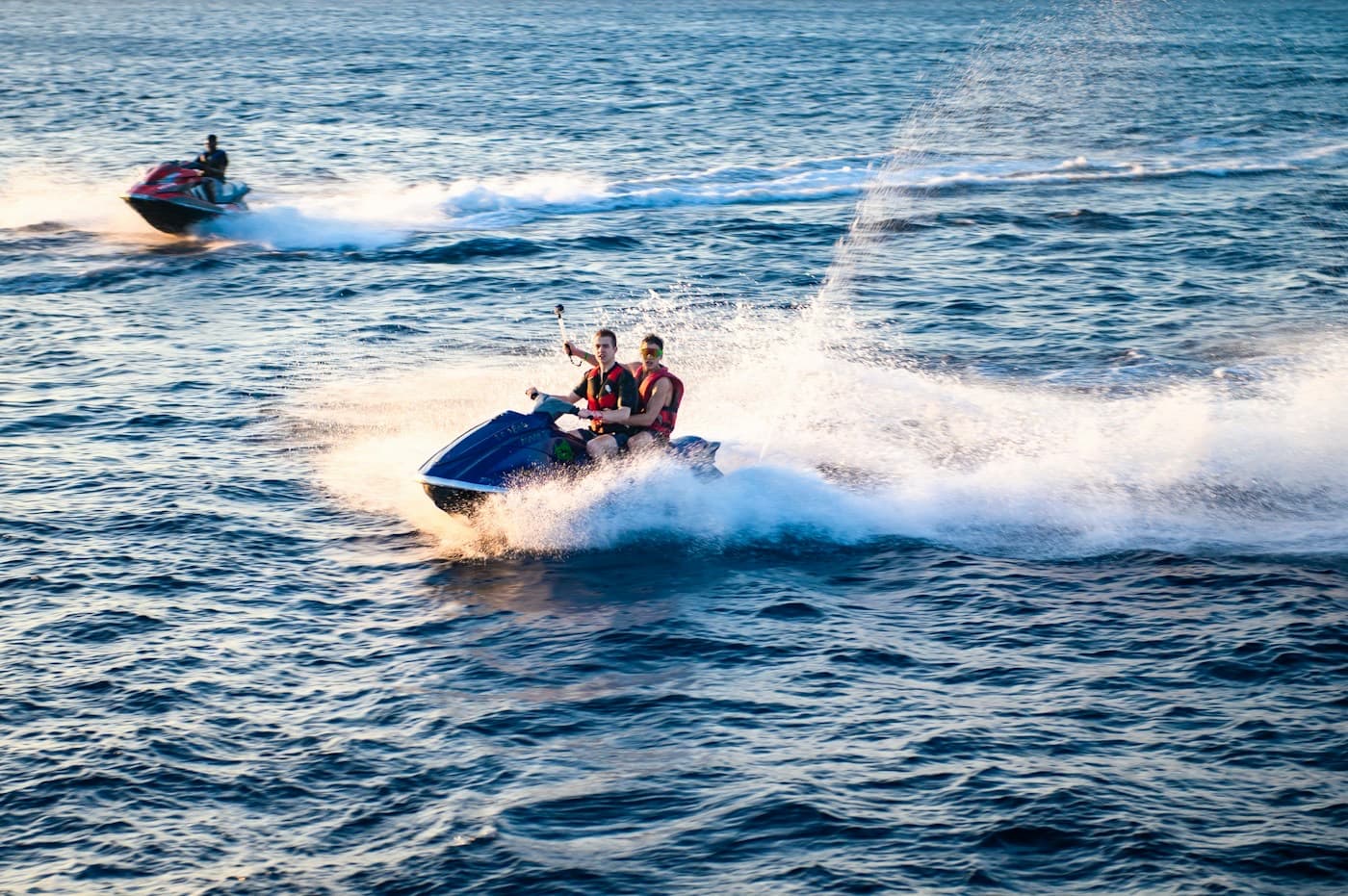 Duas pessoas pilotando um jet ski e levantando água