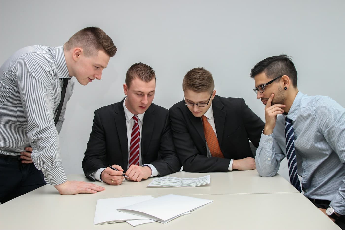 Quatro profissionais analisando um documento sobre a mesa