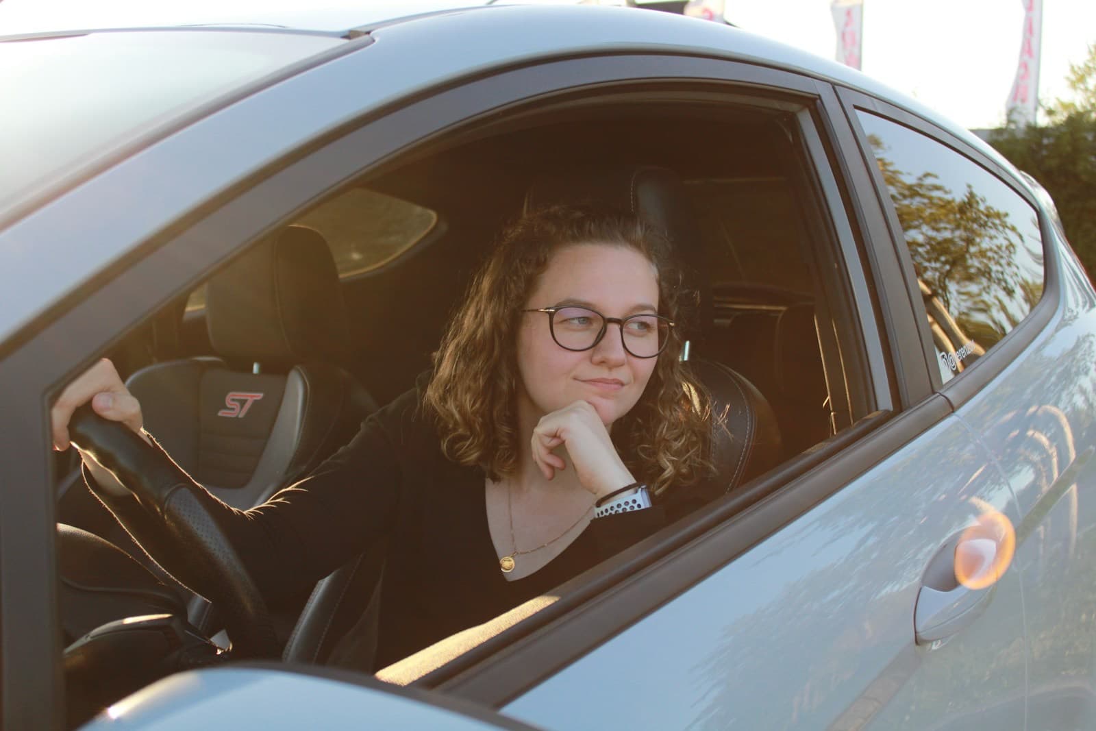 Motorista sorrindo ao volante do carro novo