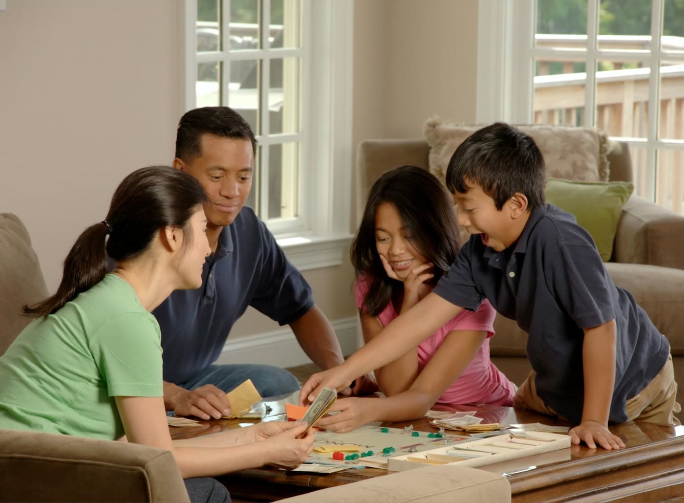 Família jogando um jogo de tabuleiro na sala